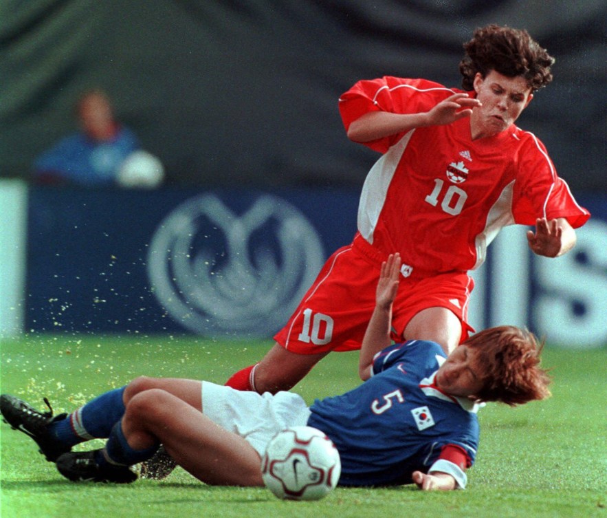 Christine Sinclair gets slide tackled by an opponent in 2002.