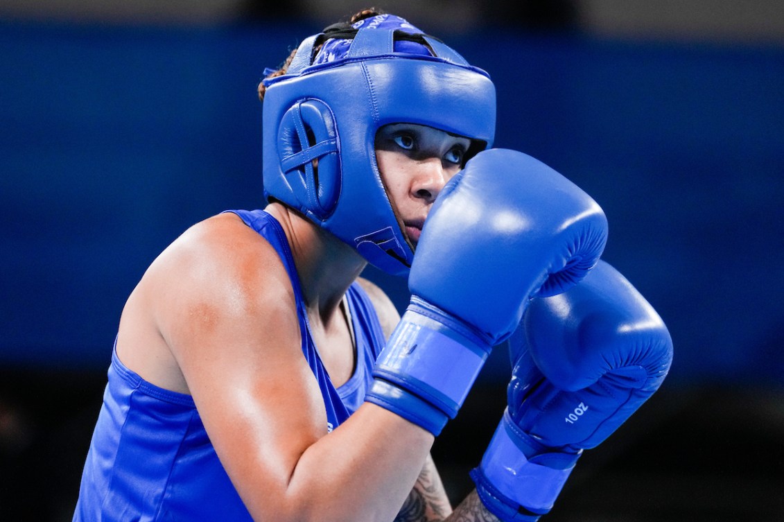 Tammara Thibeault holds her boxing gloves up in front of her face preparing to punch