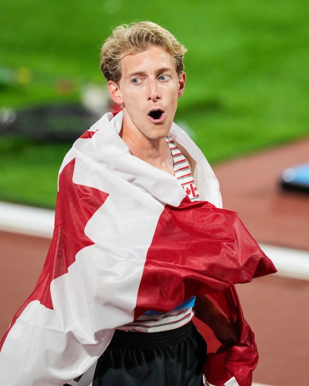Charles Philibert-Thiboutot is wrapped up in a Canadian flag post-race