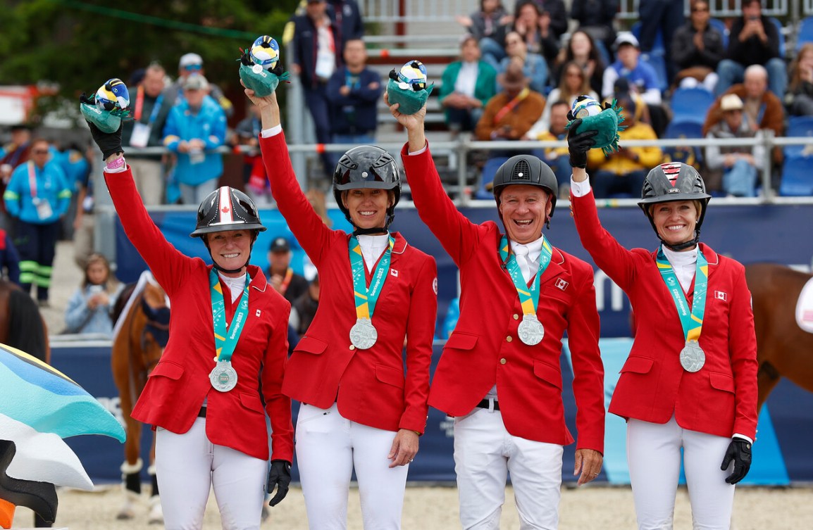 Team Canada equestrians wear their silver medals and wave to the crowd at the Pan Am Games