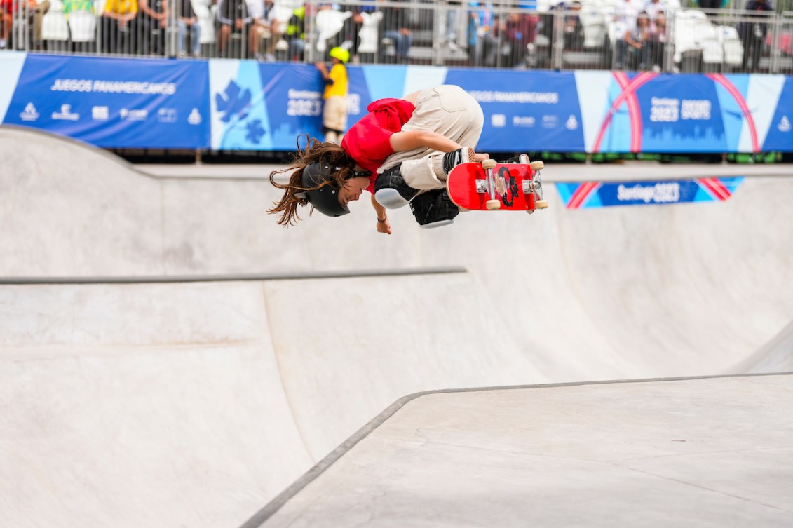 Fay De Fazio Ebert grabs her board while performing a park skateboard trick