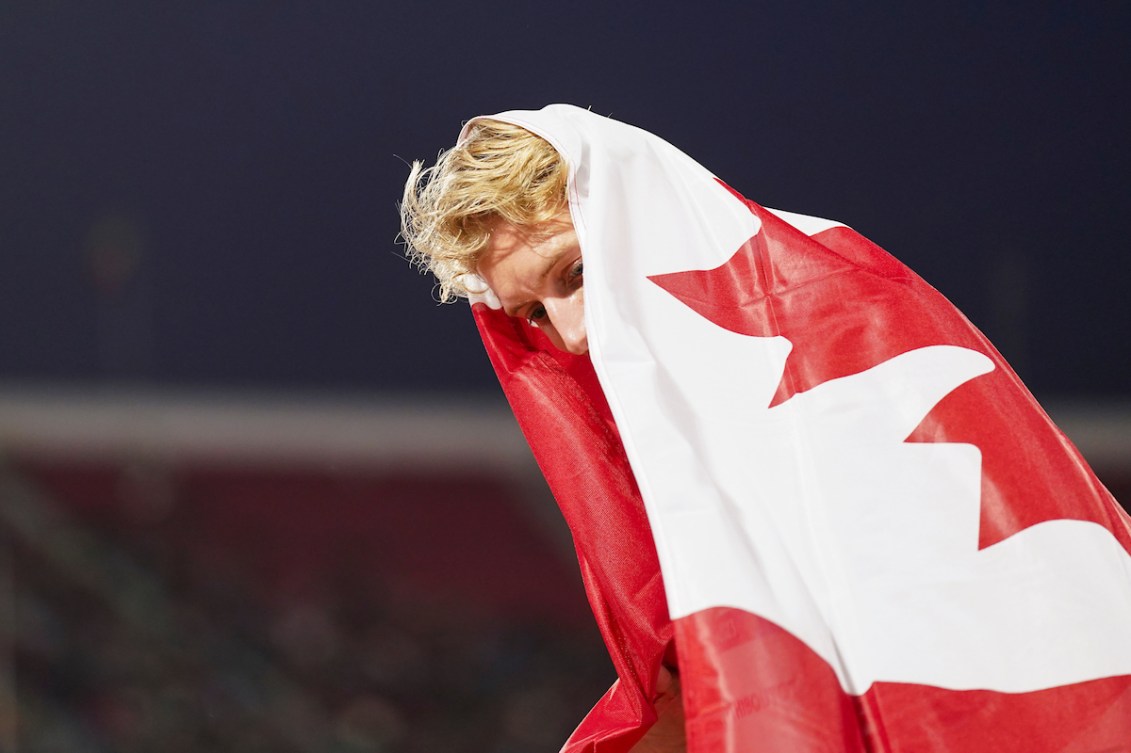 Charles Philibert-Thiboutot is wrapped up in a Canadian flag post-race