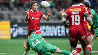 Canada's Lachlan Kratz, back left, passes the ball while being tackled by Ireland's Tom Roche