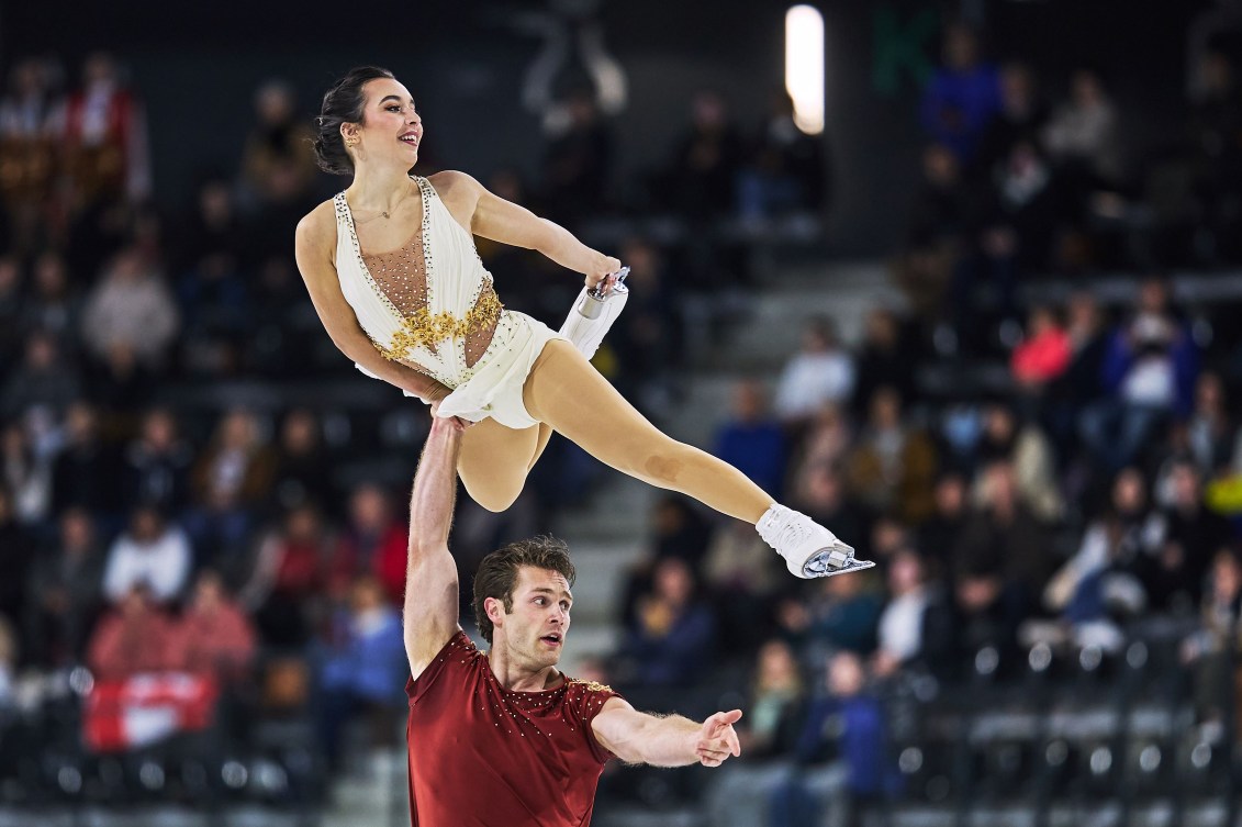 Lia Pereira and Trennt Michaud perform a pairs figure skating lift