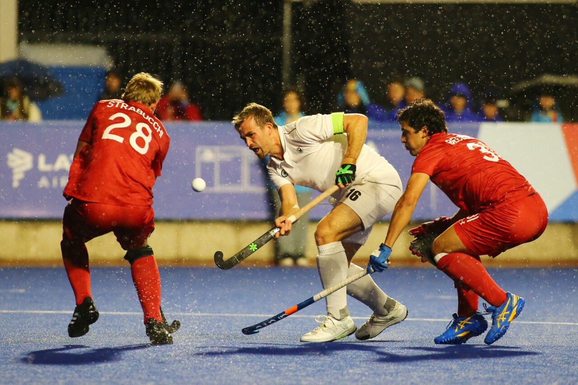 Team Canada field hockey player Gordon Johnston takes a shot while surrounded by opponents