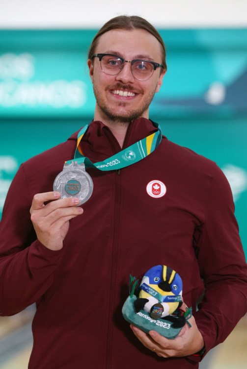 Mitch Hupé of Team Canada holds his silver medal wearing a red jacket