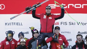 Canada's Cameron Alexander, top, celebrates with the team after taking third place in an alpine ski, men's World Cup downhill race, in Kvitfjell, Norway, Saturday, Feb. 17, 2024. (AP Photo/Alessandro Trovati)