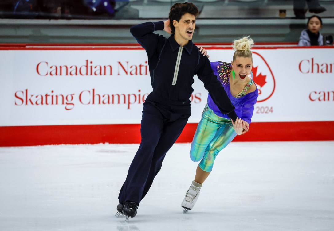 Piper Gilles and Paul Poirier dance towards the camera on ice