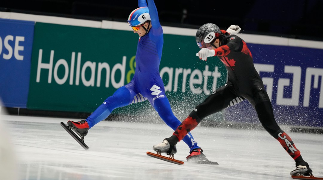 Canada's William Dandjinou, right, pushes his skate over the finish line to win the final of the men's 1000 meters ahead of Italy's Pietro Sighel, left, of the World Championships Short Track skating at Ahoy Arena in Rotterdam, Netherlands, Sunday, March 17, 2024. (AP Photo/Peter Dejong)