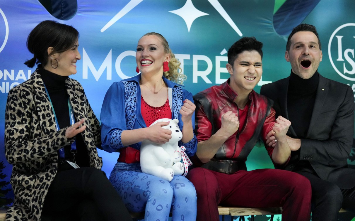 Marjorie Lajoie and Zachary Lagha celebrate with their coaches in the kiss and cry