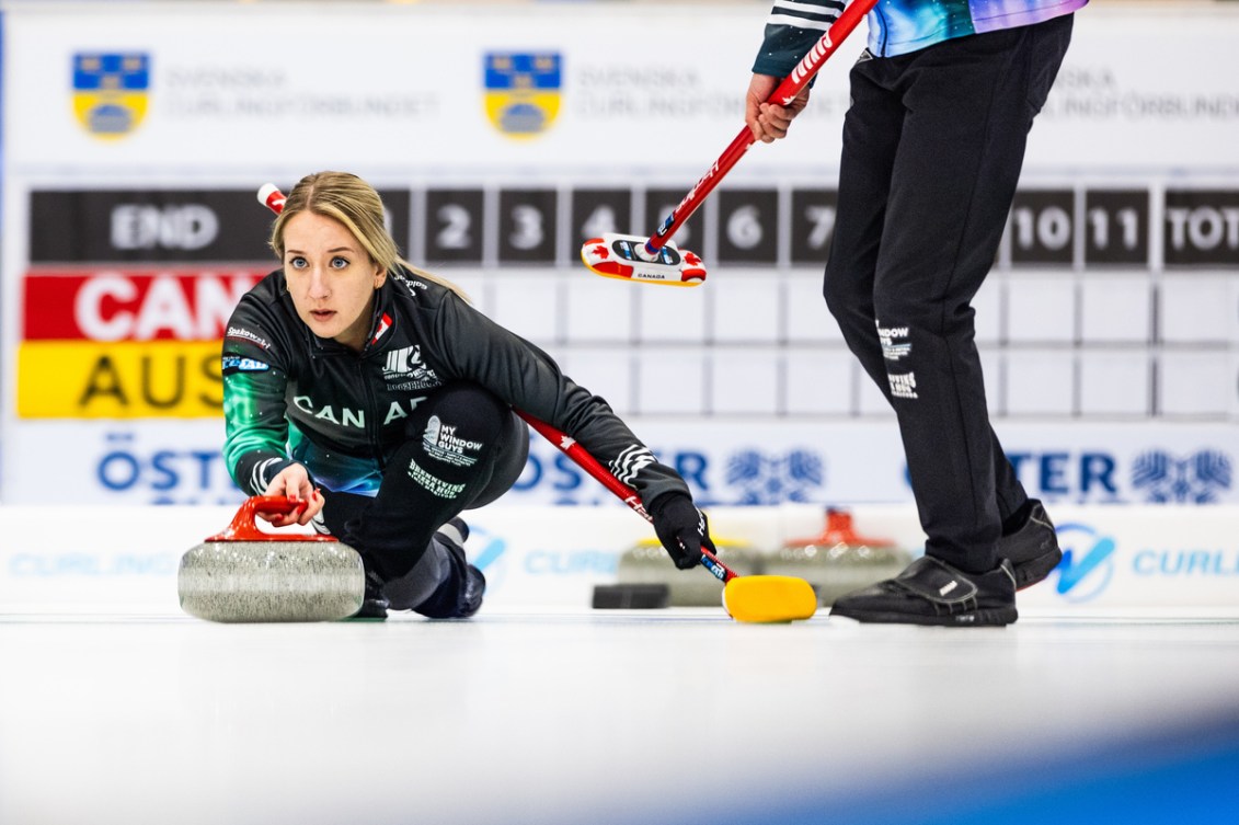 Kadriana Lott throws a red stone on curling ice