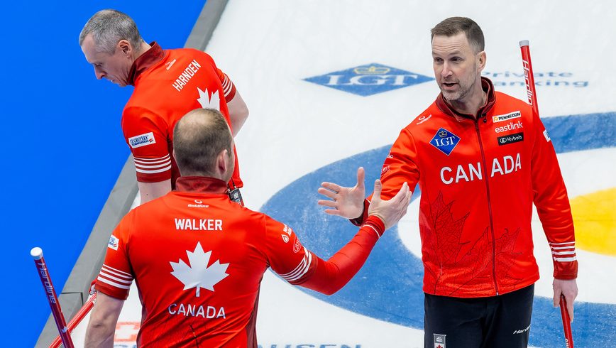 Brad Gushue and Geoff Walker shake hands on curling ice