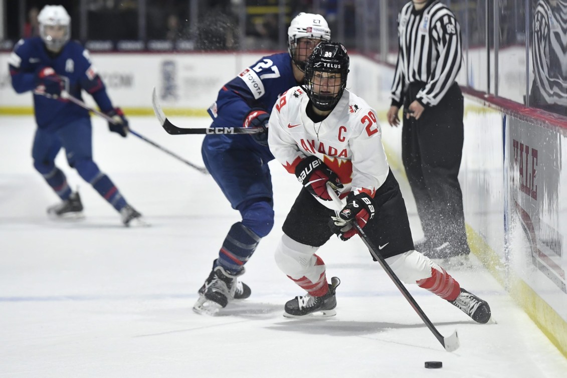 Canada forward Marie-Philip Poulin looks to pass while defended by United States forward Taylor Heise during the first period in the final at the IIHF Women's World Hockey Championships in Utica, N.Y., Sunday, April 14, 2024.