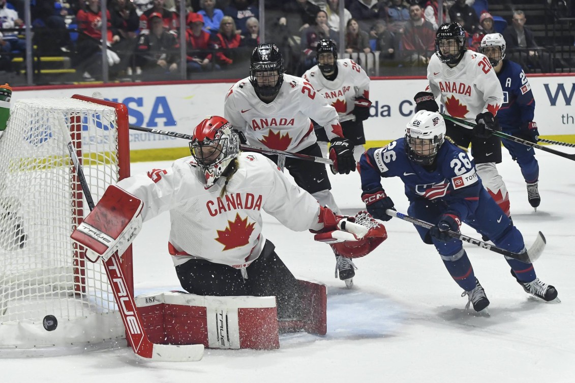 Canada goalie Ann-Renee Desbiens pushes the puck wide of the goal as United States forward Kendall Coyne Schofield chases during the second period in the final at the IIHF Women's World Hockey Championships in Utica, N.Y., Sunday, April 14, 2024.