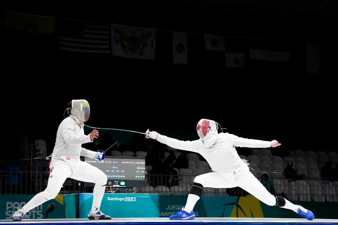 Two fencers duel on the piste