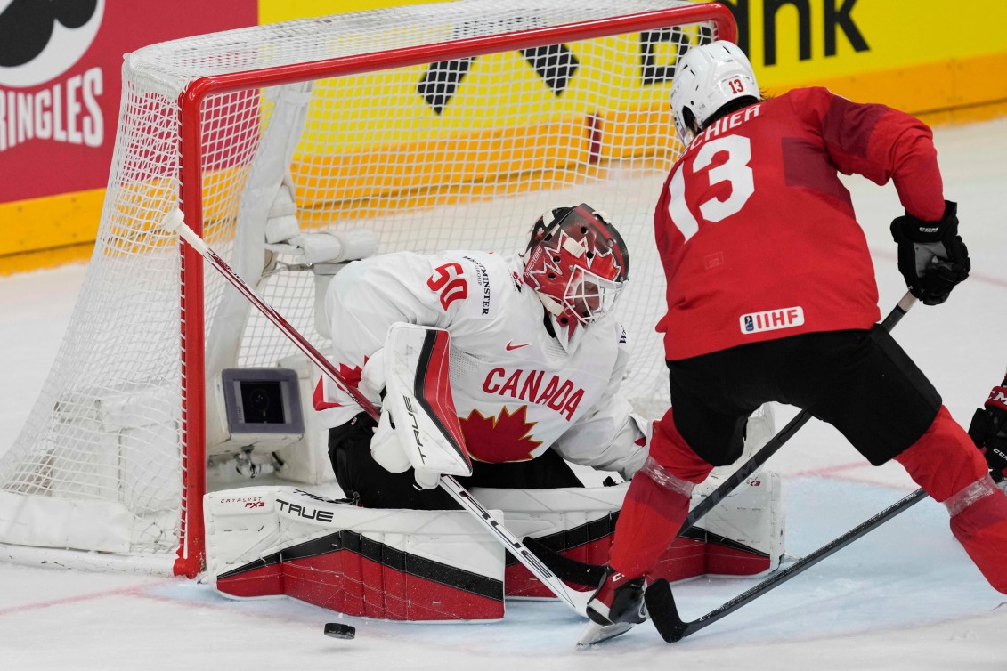 Canada's goldkeeper Jordan Binnington makes a save in front of Switzerland's Nico Hischier during the semi final match between Canada and Switzerland at the Ice Hockey World Championships in Prague, Czech Republic, Saturday, May 25, 2024.