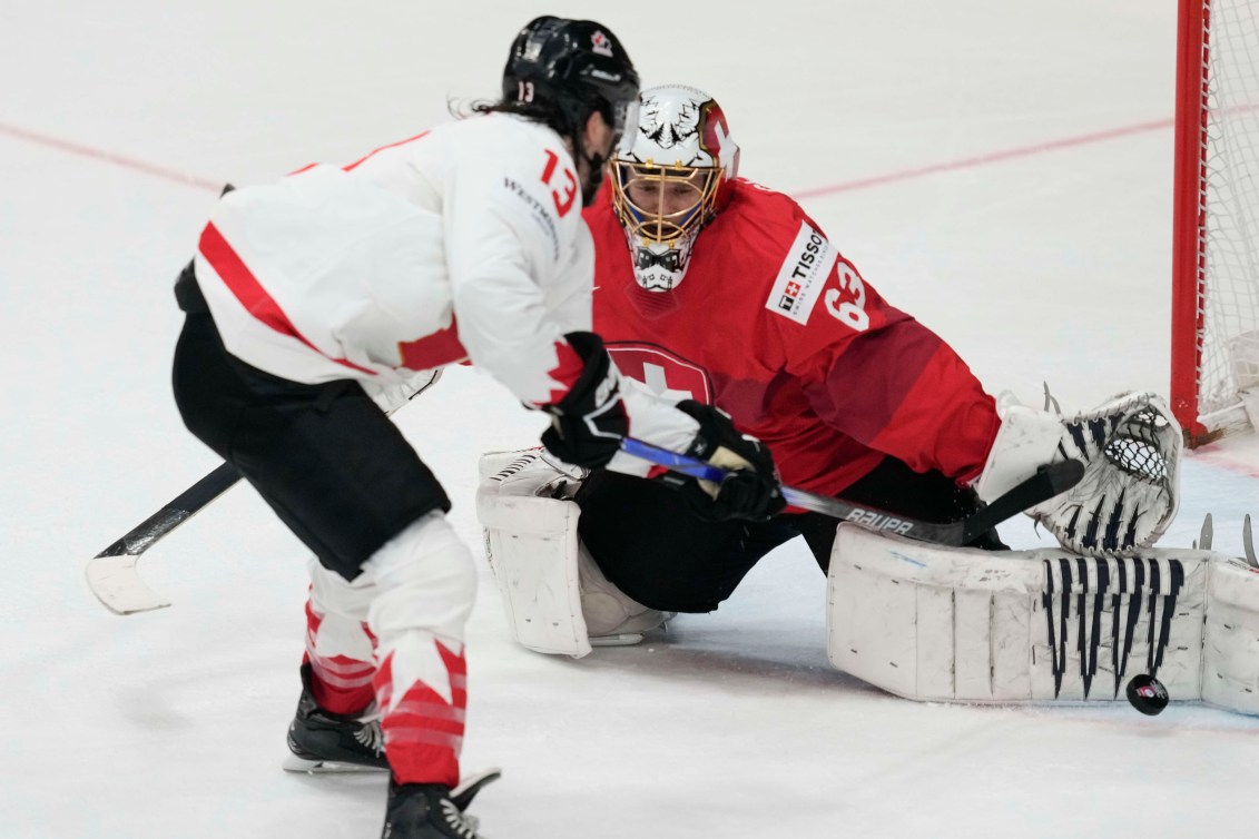 Switzerland's goalkeeper Leonardo Genoni makes a save in front of Canada's Brandon Tanev during the semi final match between Canada and Switzerland at the Ice Hockey World Championships in Prague, Czech Republic, Saturday, May 25, 2024.