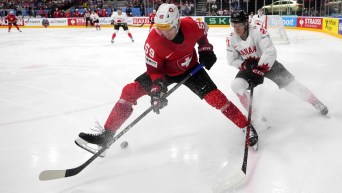 Canada's Kaiden Guhle challenges Switzerland's Dario Simion during the semifinal match between Canada and Switzerland at the Ice Hockey World Championships in Prague, Czech Republic, Saturday, May 25, 2024.