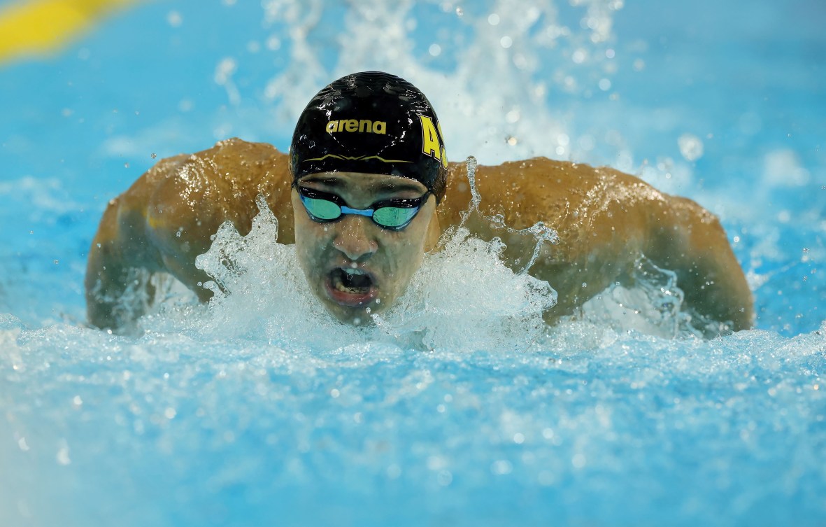 Ilya Kharun in a black swim cap swims butterfly stroke 