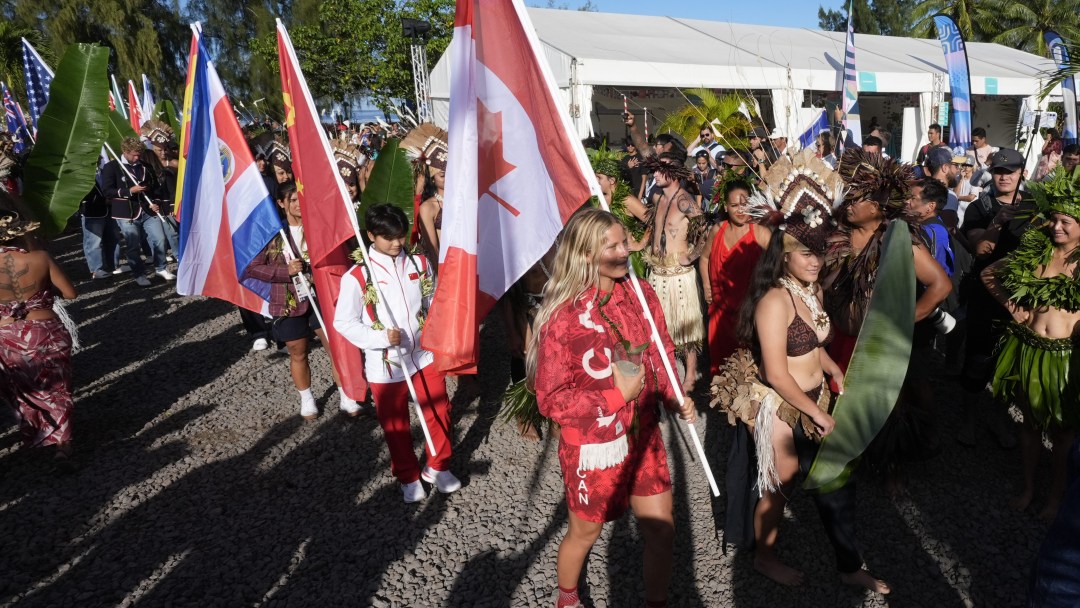 Sanoa Dempfle-Olin walks in the Opening Ceremony in Tahiti carrying the Canadian flag