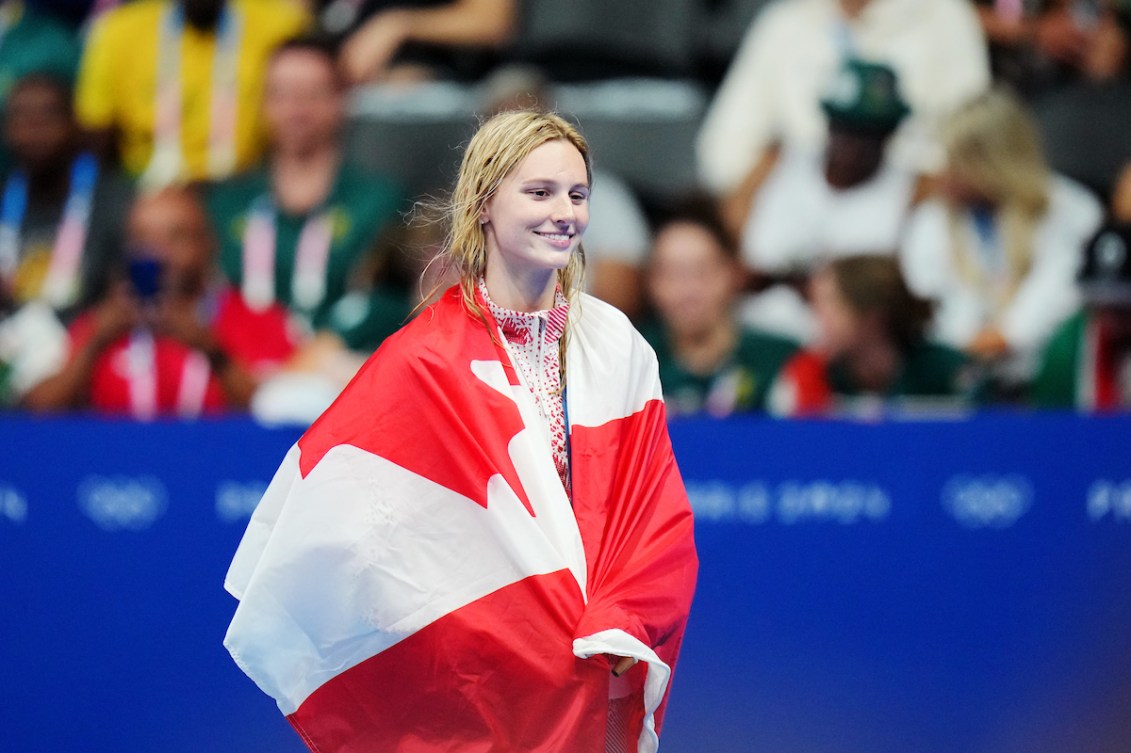 Summer McIntosh is draped in a Canada flag