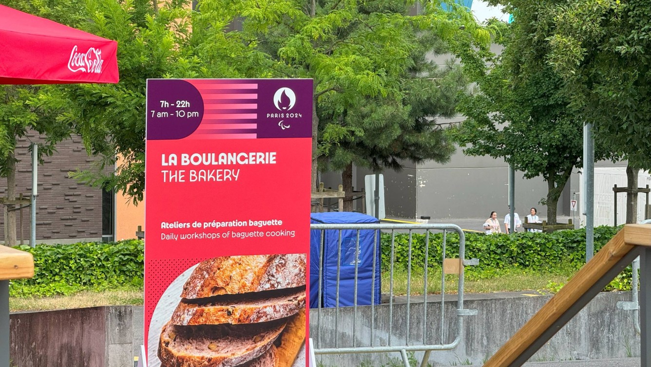 A sign offering baguette-making lessons stands in an open area