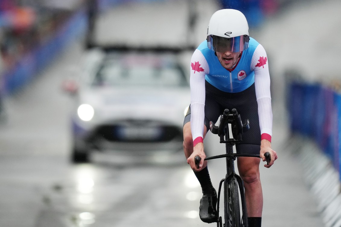 Derek Gee races in the time trial wearing a blue and white jersey