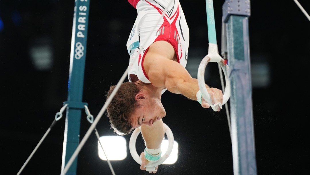 William Emard performs a handstand on the rings.