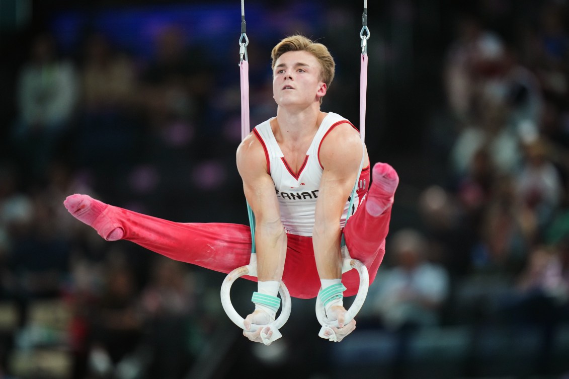 Felix Dolci raises his legs above his hands on the rings