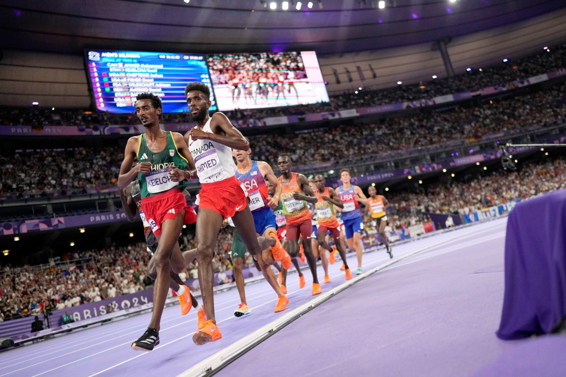 Yomif Kejelcha, of Ethiopia, left, and Mohammed Ahmed, right, of Canada, compete in the men's 10000 meters final at the 2024 Summer Olympics, Friday, Aug. 2, 2024, in Saint-Denis, France. (AP Photo/Matthias Schrader