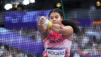 Camryn Rogers swings a hammer in front of netting