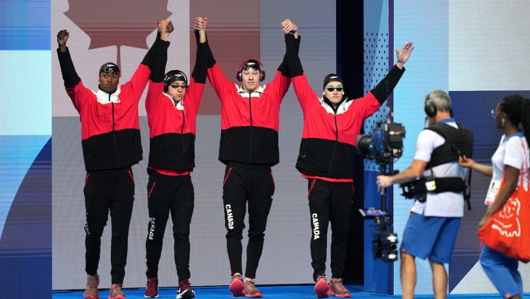 Team Canada’s men's 4x100m medley relay team raises their arms together