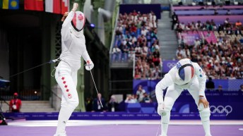 Eleanor Harvey pumps her fist in the air while her French fencing opponent leans on her knees in sadness