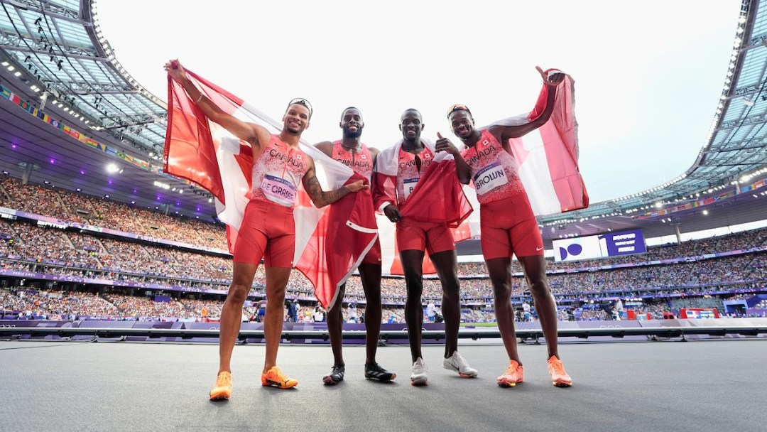 Team Canada celebrates after winning men's 4x100m relay gold.