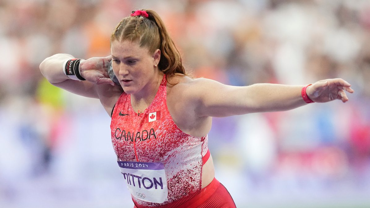 Sarah Mitton prepares to throw the shot put while wearing a pink singlet