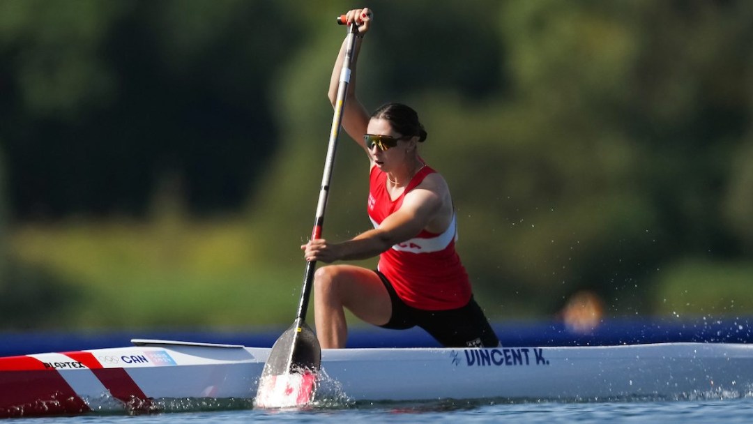 Katie Vincent paddles her canoe while wearing a red Team Canada singlet