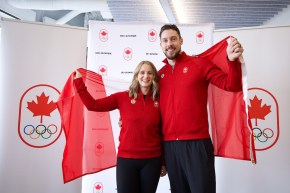 Dressed in red tops and black pants Jocelyn Peterman and Brett Gallant hold a Canadian flag behind them
