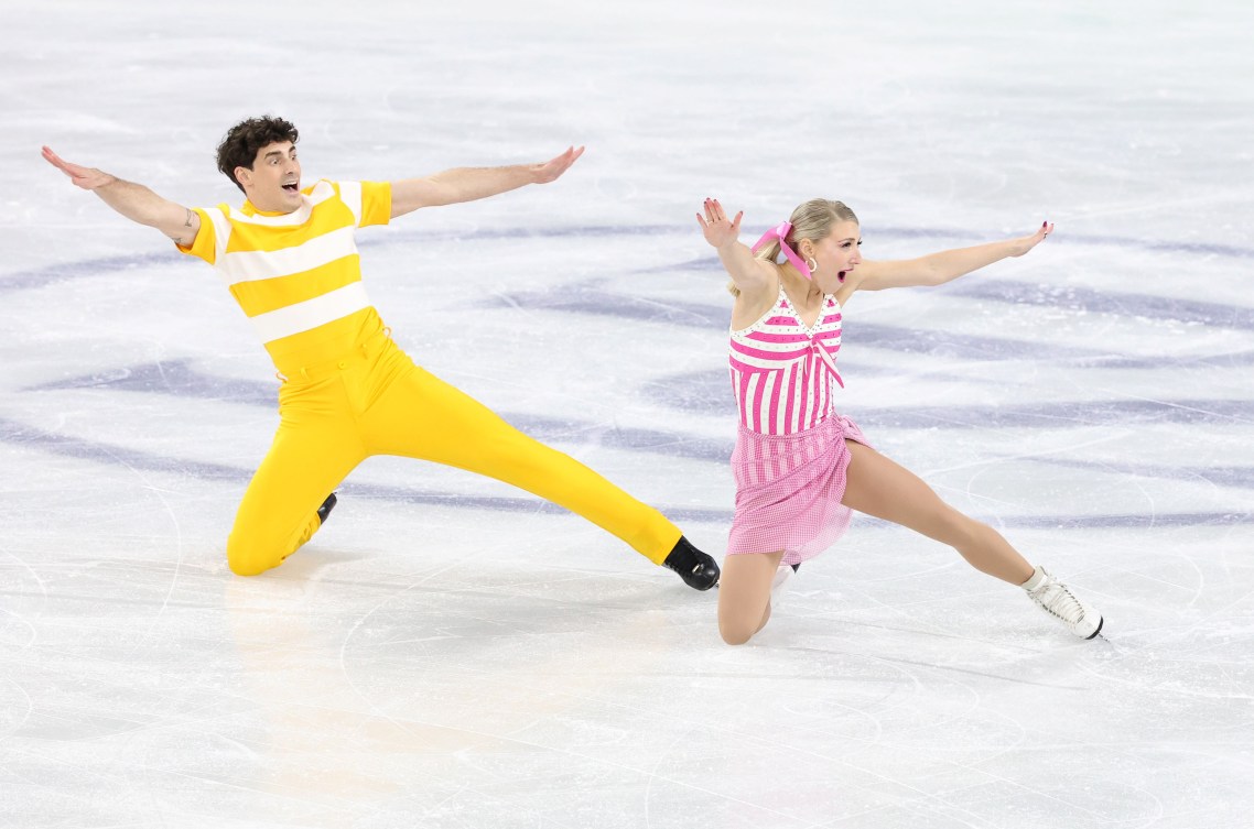 Piper Gilles in a pink dress and Paul Poirier in yellow pants and shirt perform on the ice