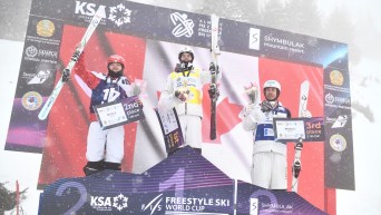Mikael Kingsbury stands on the top of the podium