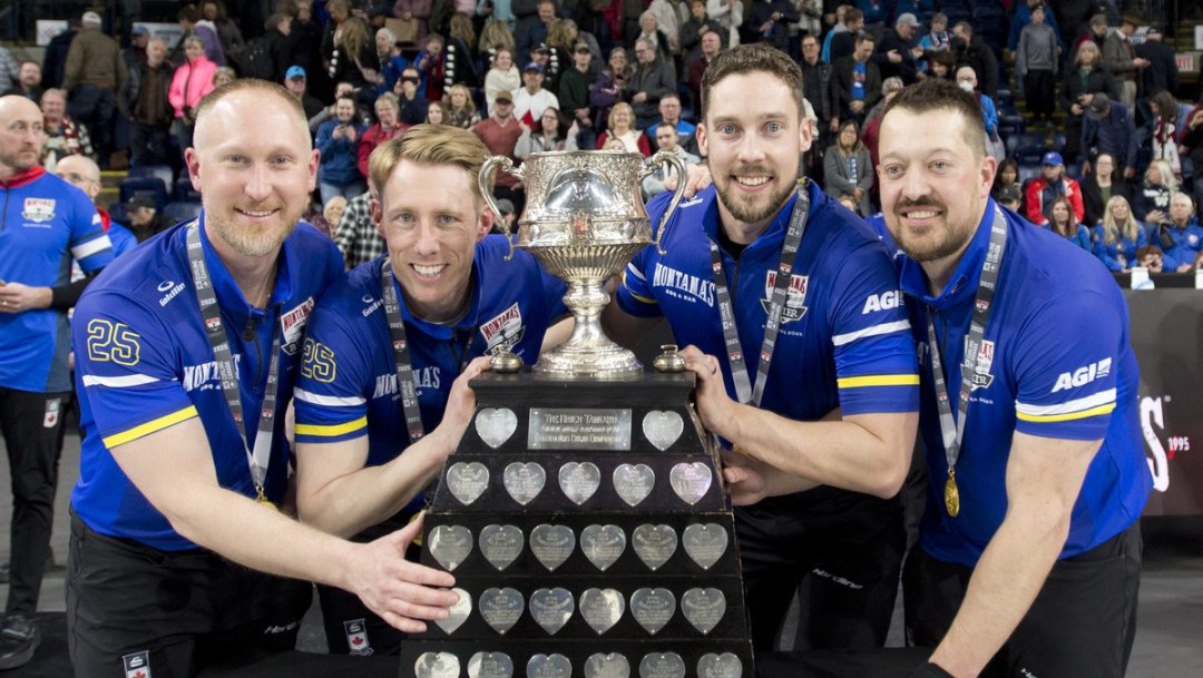 Team Jacobs pose with a large trophy while wearing blue shirts