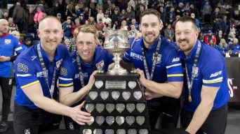Team Jacobs pose with a large trophy while wearing blue shirts