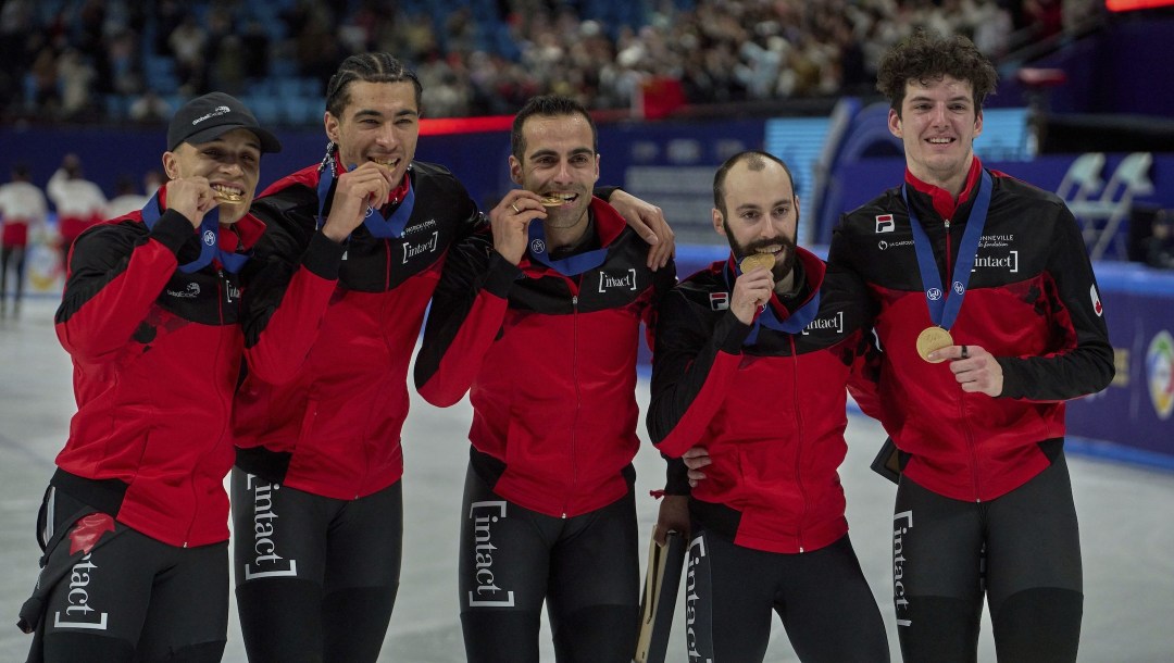 The members of the first placed team Canada pose with their medals after the Men's 5000m Relay Finals of the ISU World Short Track Championships in Beijing.