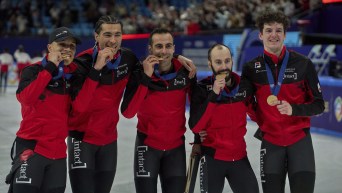 The members of the first placed team Canada pose with their medals after the Men's 5000m Relay Finals of the ISU World Short Track Championships in Beijing.