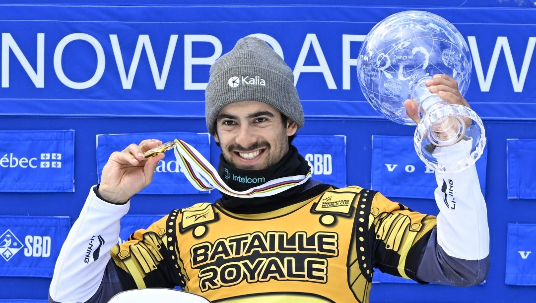 Eliot Grondin, of Sainte-Marie, Que., raises the Crystal Globe for the season’s overall winner, Sunday, April 6, 2025 at the FIS snowboard cross world cup event at Mont-Sainte-Anne resort in Beaupre, Quebec.