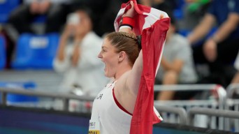 Sarah Mitton has her photo take from the side while she holds a Canada flag over her shoulders