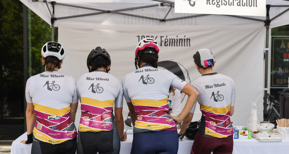 Four cyclists in gear with their backs to the photographer