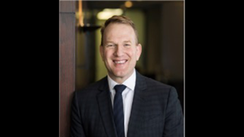 man wearing suit smiles at camera