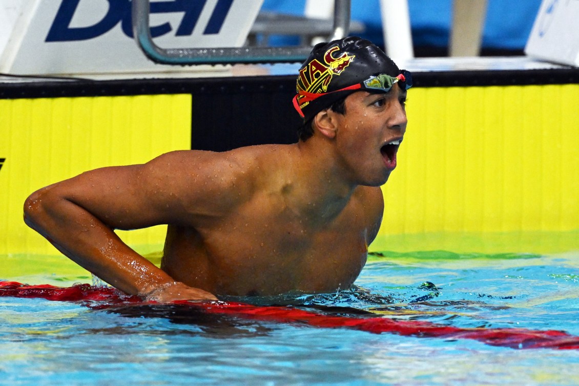 Ethan Ekk yells as he hangs on the lane rope at the end of the pool