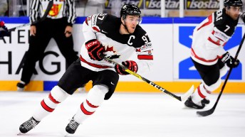 Connor McDavid in a white Team Canada jersey skates on the ice