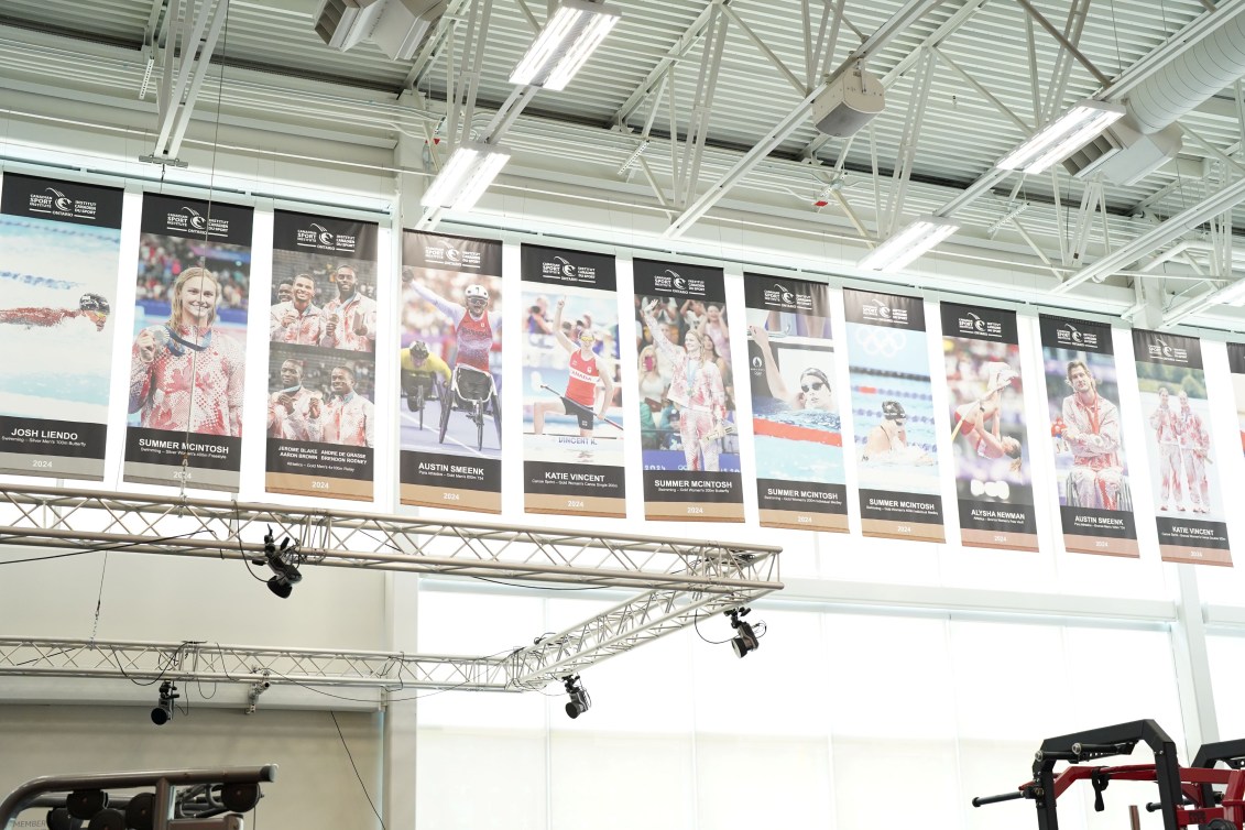 Banners of Olympic and Paralympic medallists hang at the top of a wall